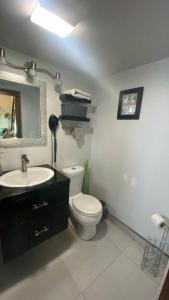 a bathroom with a toilet and a sink and a mirror at Casa Edka in Ensenada