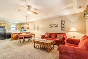 a living room with a red couch and a table at Branson Condo at Stonebridge Golf Resort with Pool and Wi-Fi near Silver Dollar City and 76 in Reeds Spring