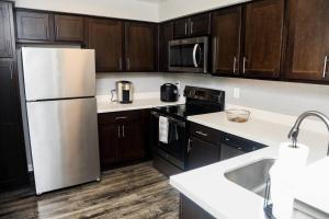 a kitchen with a white refrigerator and wooden cabinets at Apartment in Houston Med Center in Houston