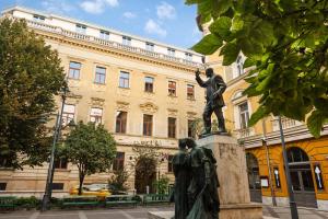 Eine Statue eines Mannes, der vor einem Gebäude steht. in der Unterkunft Eurostars Palazzo Zichy in Budapest