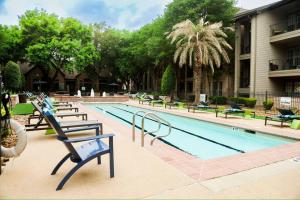 a swimming pool with several chairs around it at Apartment in Houston Med Center in Houston