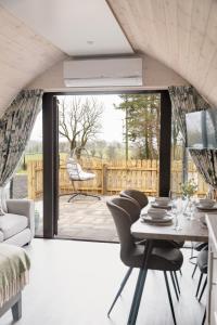a living room with a table and chairs and a large window at Coolaness Glamping in Irvinestown