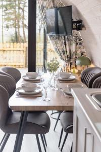 a wooden table with chairs and a television on top at Coolaness Glamping in Irvinestown