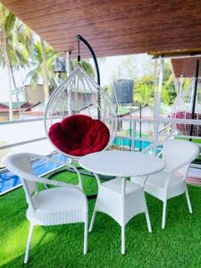 ein weißer Tisch und Stühle mit einer Glasschüssel darauf in der Unterkunft Luxurious Beach Resort Agonda in Agonda