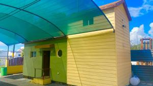 a small yellow and green house with a blue roof at Casa Edka in Ensenada