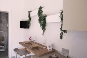 a dining room table with wine glasses and ivy on the wall at Broom House in San Foca
