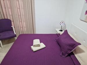 a purple bed with a purse sitting on top of it at Vila Lavanda in Playa de las Americas