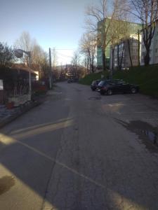 比哈奇Hostel Mlinar的一条空荡荡的街道,有汽车停在停车场