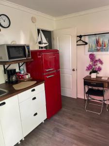 a red refrigerator in a kitchen with a table at Lovely Studio Apartment with Kitchenette. in Tampa
