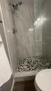 baño con ducha y suelo blanco y negro en Lovely Studio Apartment with Kitchenette. en Tampa