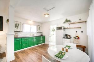 una cocina con armarios verdes y una mesa blanca en SweetPea Tiny Home, en Boise