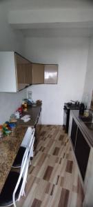 a small kitchen with a counter top and a wooden floor at Hostel do Coreto in Mucugê