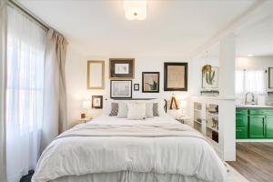 1 dormitorio blanco con 1 cama grande y cocina en SweetPea Tiny Home, en Boise