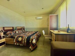 a bedroom with two beds and a desk and a bed sidx sidx sidx at Quiet Apartment in Redemption Camp, Ogun State in Pakuro