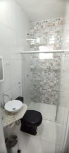 a bathroom with a shower and a toilet and a sink at Hostel do Coreto in Mucugê
