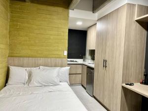 1 dormitorio pequeño con 1 cama y cocina en Loft Belmont Suites 202, en Pereira