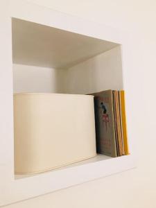 uma prateleira branca com um livro e um espelho em PUNTO FERMO in Verona center 023091-LOC-01911 em Verona