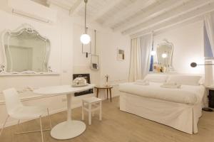 um quarto branco com uma cama branca e uma mesa em PUNTO FERMO in Verona center 023091-LOC-01911 em Verona