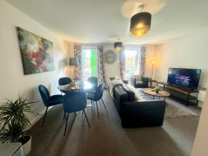 a living room with a couch and a table and chairs at Blueberry Tree Apartment in Cambridge