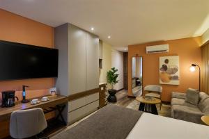 a hotel room with a television and a living room at Blues Suites Medellín in Medellín
