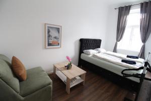 a bedroom with a bed and a chair and a table at Spacious Apartment in Liesing Area LV5 in Vienna