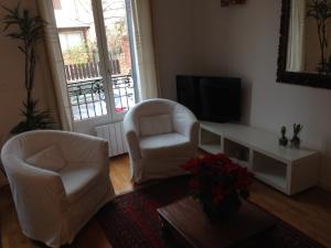 a living room with two chairs and a television at Appartement Comme Une Petite Maison in Malakoff