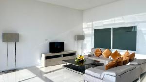 a living room with a couch and a tv at A2-stunning Seaview 4brs3baths Duplex karon City in Ban Karon