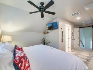 a bedroom with a white bed with a ceiling fan at Blue Sky Bungalow in Boise