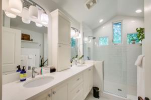 a white bathroom with two sinks and a shower at Blue Sky Bungalow in Boise