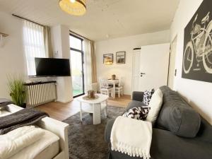 a living room with a couch and a table at Ferien im Wangerland - Haus Wiesenweg - Apartment 2 1OG in Wangerland