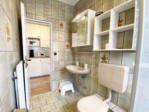 Un baño pequeño con inodoro y lavabo. en Ferien im Wangerland - Haus Wiesenweg - Apartment 2 1OG, en Horumersiel