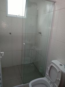 La salle de bains est pourvue d'une douche, de toilettes et d'une fenêtre. dans l'établissement Apto térreo com ar condicionado próximo a praia Maranduba, à Ubatuba