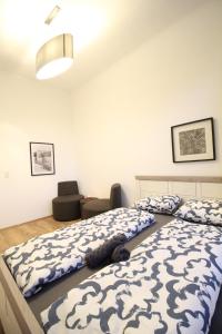 1 dormitorio con 2 camas y 1 silla en Spacious Apartment in Liesing Area LV6 en Viena