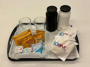 ein Plastiktablett mit einem Behälter aus Speisen und Getränken in der Unterkunft Só Love Hotel in São Paulo