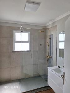 La salle de bains est pourvue d'une douche et d'un lavabo. dans l'établissement Figueira's House By the Atlantic, à Ponta do Sol