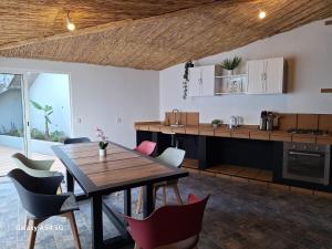 a kitchen and dining room with a wooden table and chairs at Figueira's House By the Atlantic in Ponta do Sol