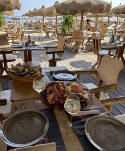 einen Tisch mit einem Teller mit Essen und Gläsern Wein in der Unterkunft Le Saint Roch in Menton