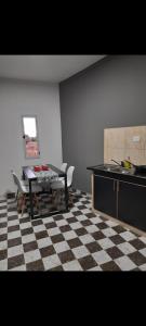 uma cozinha com uma mesa e um piso em xadrez em Arena blanca em Fiambalá