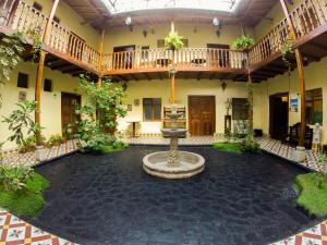 einen Innenhof mit einem Brunnen in der Mitte eines Gebäudes in der Unterkunft Casa Bonita Colonial in Cajamarca