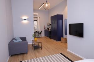a living room with a couch and a flat screen tv at Maze Apartments - Perfectly located brand new flats in Tel Aviv