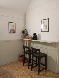 2 sillas y un mostrador en una habitación con paredes blancas en La Cabana en Organyà