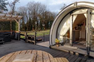 une tente en forme de dôme sur une terrasse avec une table dans l'établissement Coolaness Glamping, à Irvinestown
