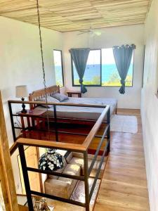 a bedroom with a bed swing in a room at Cotinga Nest - King Bed, Ocean View in San Pedrillo