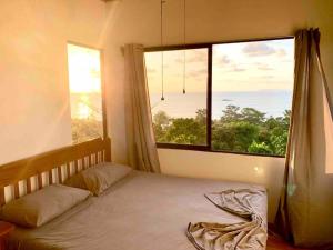 a bedroom with a bed and a large window at Cotinga Nest - King Bed, Ocean View in San Pedrillo
