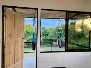 a room with a window with a swing at Cotinga Nest - King Bed, Ocean View in San Pedrillo