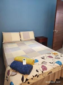 uma cama com um cobertor e almofadas em Casa de Alexita em Puerto Baquerizo Moreno