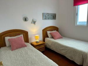 a bedroom with two beds and a lamp on a table at Acogedora casita in El Charco