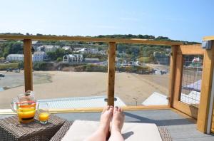 亞博波斯的住宿－Pabell Pren Glamping - by Aberporth Beach Holidays，坐在阳台上的人,脚踏在桌子上