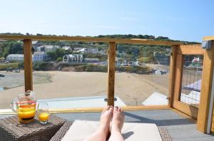 a person sitting on a balcony with their feet on a table at Pabell Pren Glamping - by Aberporth Beach Holidays in Aberporth