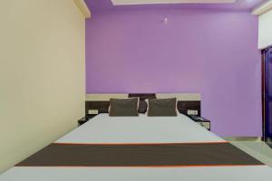 a bedroom with a large bed with a purple wall at Collection O Siddhi Vinayak Hotel & Banquets in Motīhāri